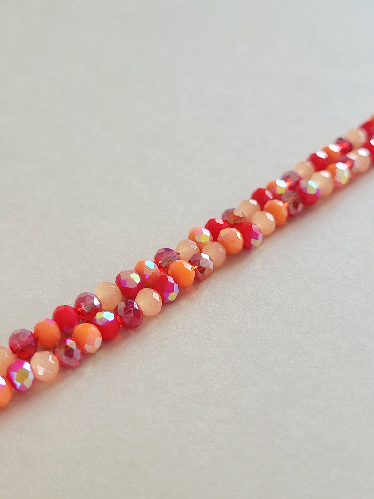 Pienet punaiset ja oranssit lasihelmet